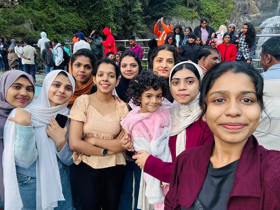 Team members on an outing near a waterfall